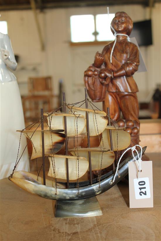 Far Eastern hardwood carving of a fruit seller & a horn model of a sailing ship